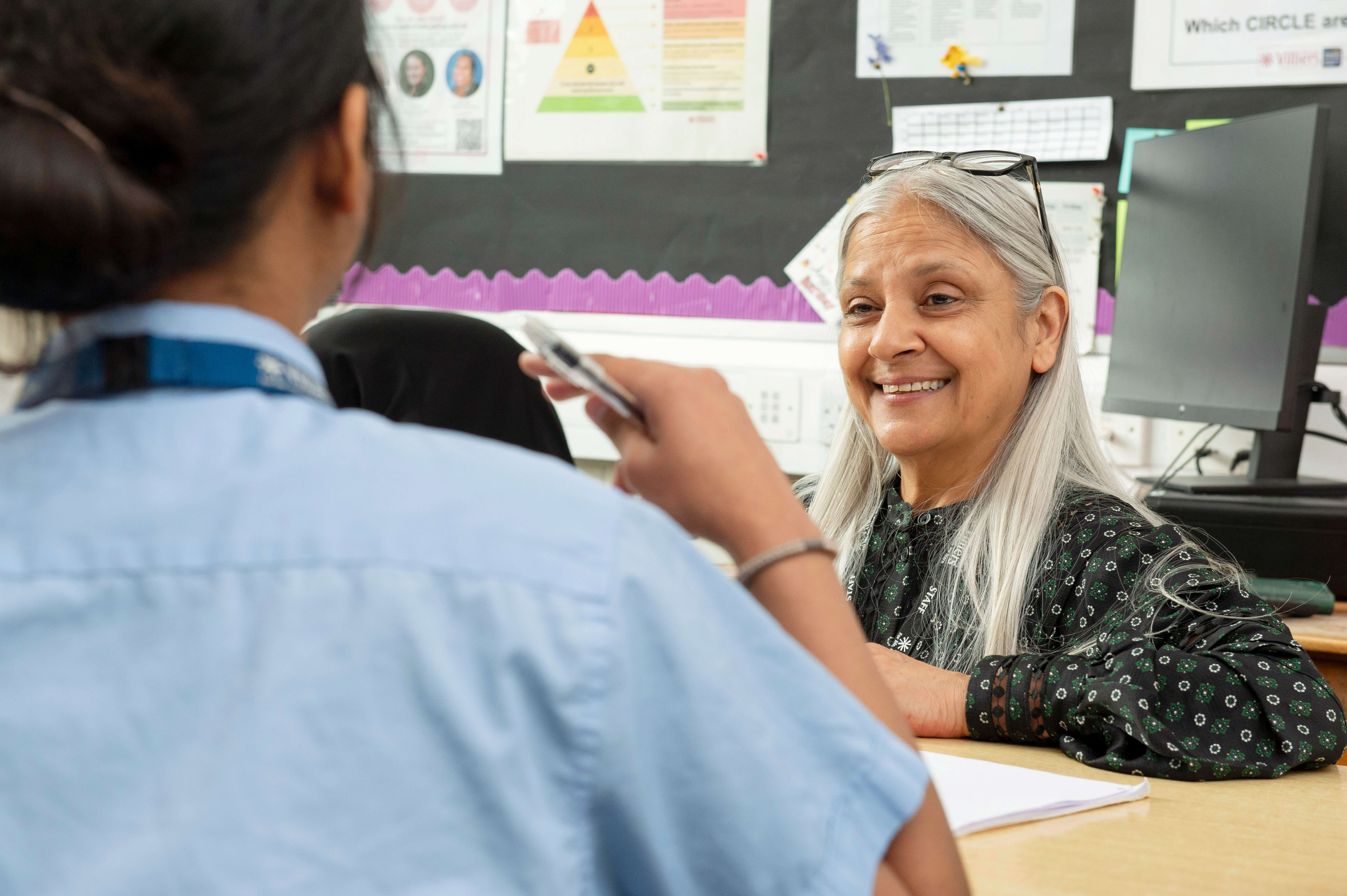 Teacher smiling while talking to a student